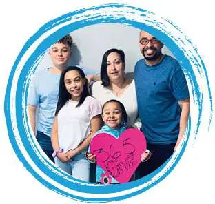 The Howze Family posing together with a heart-shaped ‘365give’ sign.