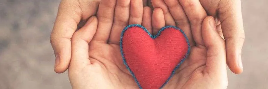 Two hands gently holding a red heart, representing care, compassion, and acts of love. Small gestures like these make the world a kinder place! #all4Love
