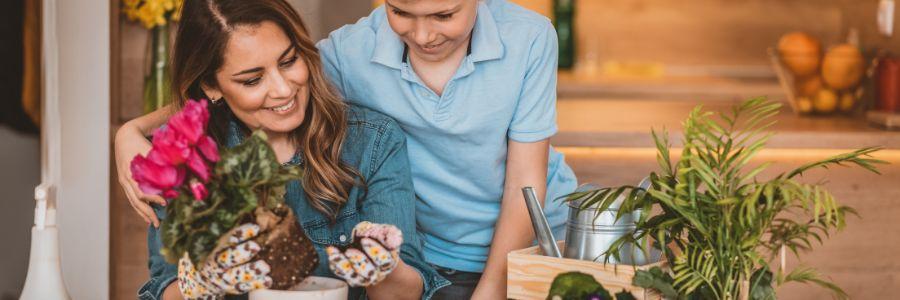 A mother and son planting flowers together in the kitchen—bonding through meaningful Mother’s Day activities.