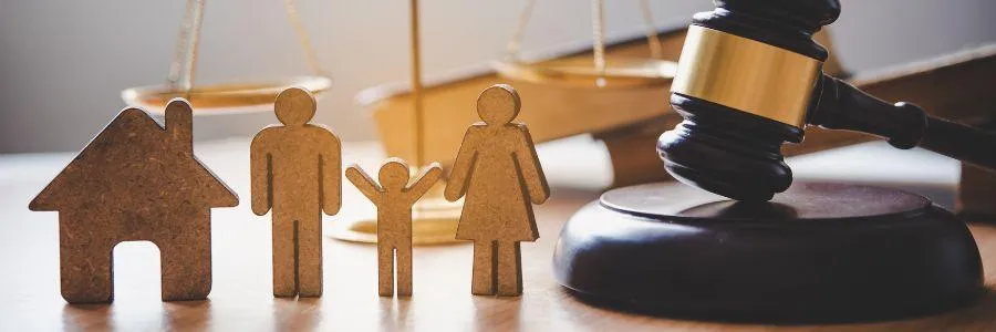 Wooden cutouts of a family, house, and gavel highlighting the importance of family giving and wellness on the International Day of Families
