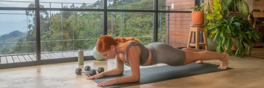 Woman practicing plank exercise indoors as part of her mental wellness and self-care routine. 