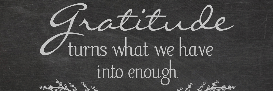 Purple coffee cup beside a napkin with the words “Practice gratitude daily” written in blue ink.