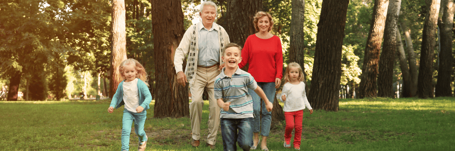 Grandparents walking with grandchildren in the park, enjoying family time to celebrate Grandparents Day
