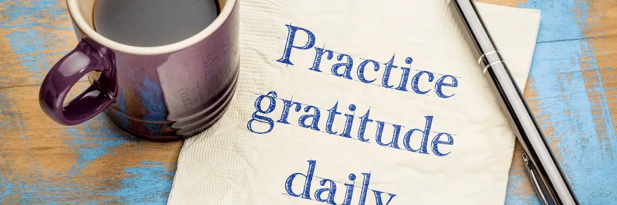 Inspirational chalkboard quote: “Gratitude turns what we have into enough,” decorated with simple white branches