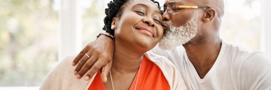 A couple sharing a gentle kiss and hug, showing secure love and emotional closeness