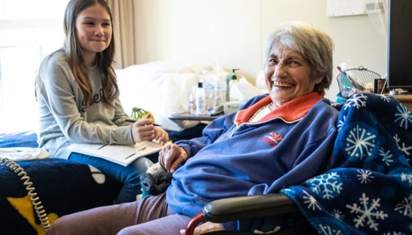 Young girl visiting and spending time with an elderly woman as part of an act of giving.