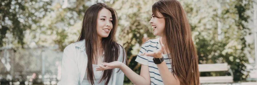 Two friends or classmates talking naturally while walking outdoors