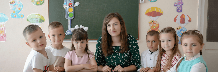 Teacher and students in a classroom sharing ideas for a happiness jar activity to support happy students