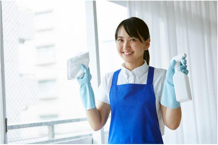  Person using a reusable cleaning spray bottle as part of a low-waste home routine
