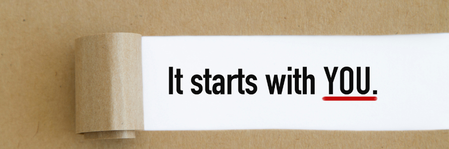 Paper scroll displaying the motivational message “It starts with YOU.”