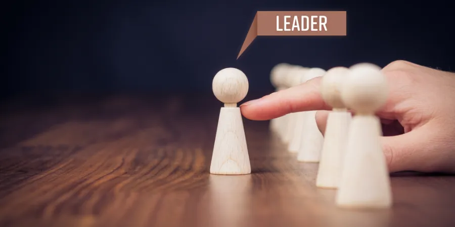 Wooden figure selected as a leader from a group, representing leadership skills for students, responsibility, and personal growth.